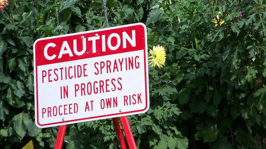 Caution sign in a field with pesticides